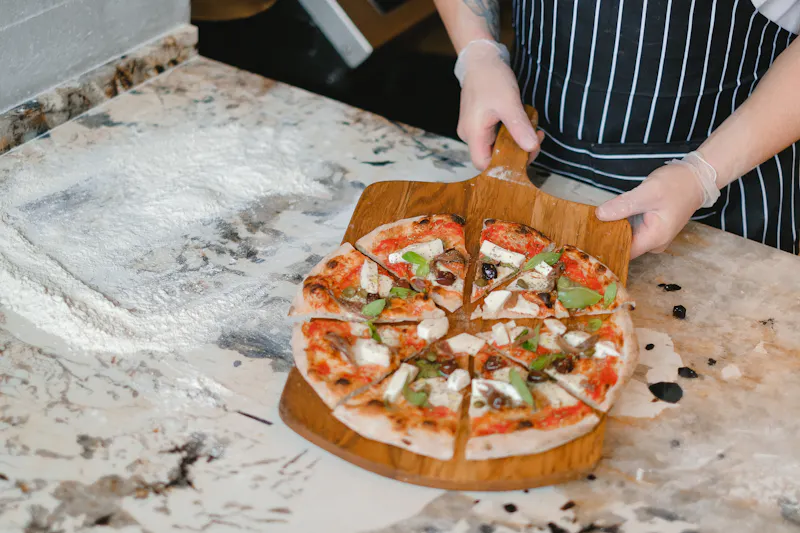 Fresh pizza being prepared in our kitchen with quality ingredients